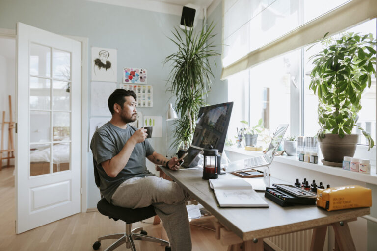 Digital artist contemplates during coffee break in his home office